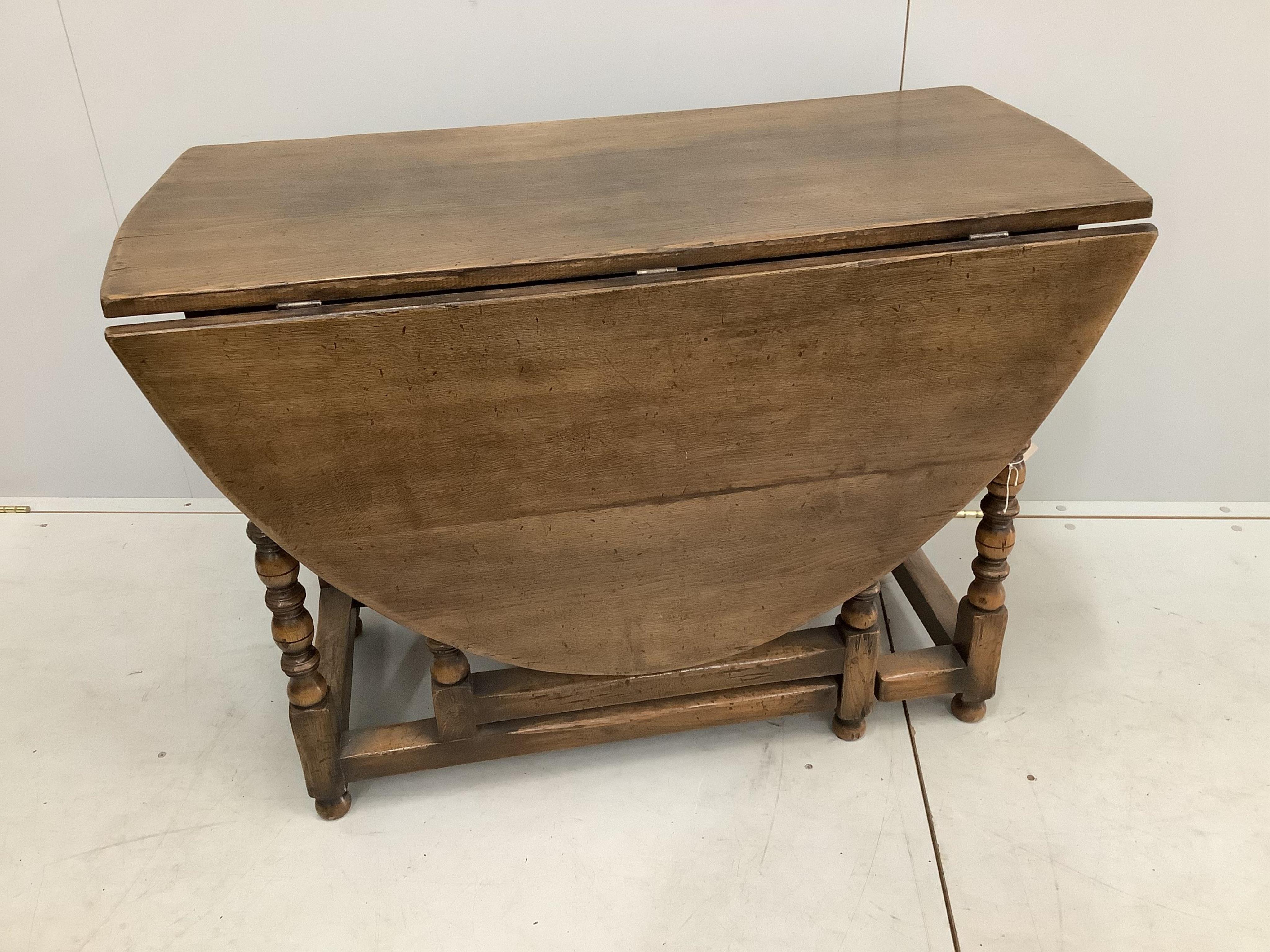 A reproduction 18th century style oak gateleg dining table, width 106cm, depth 50cm, height 73cm